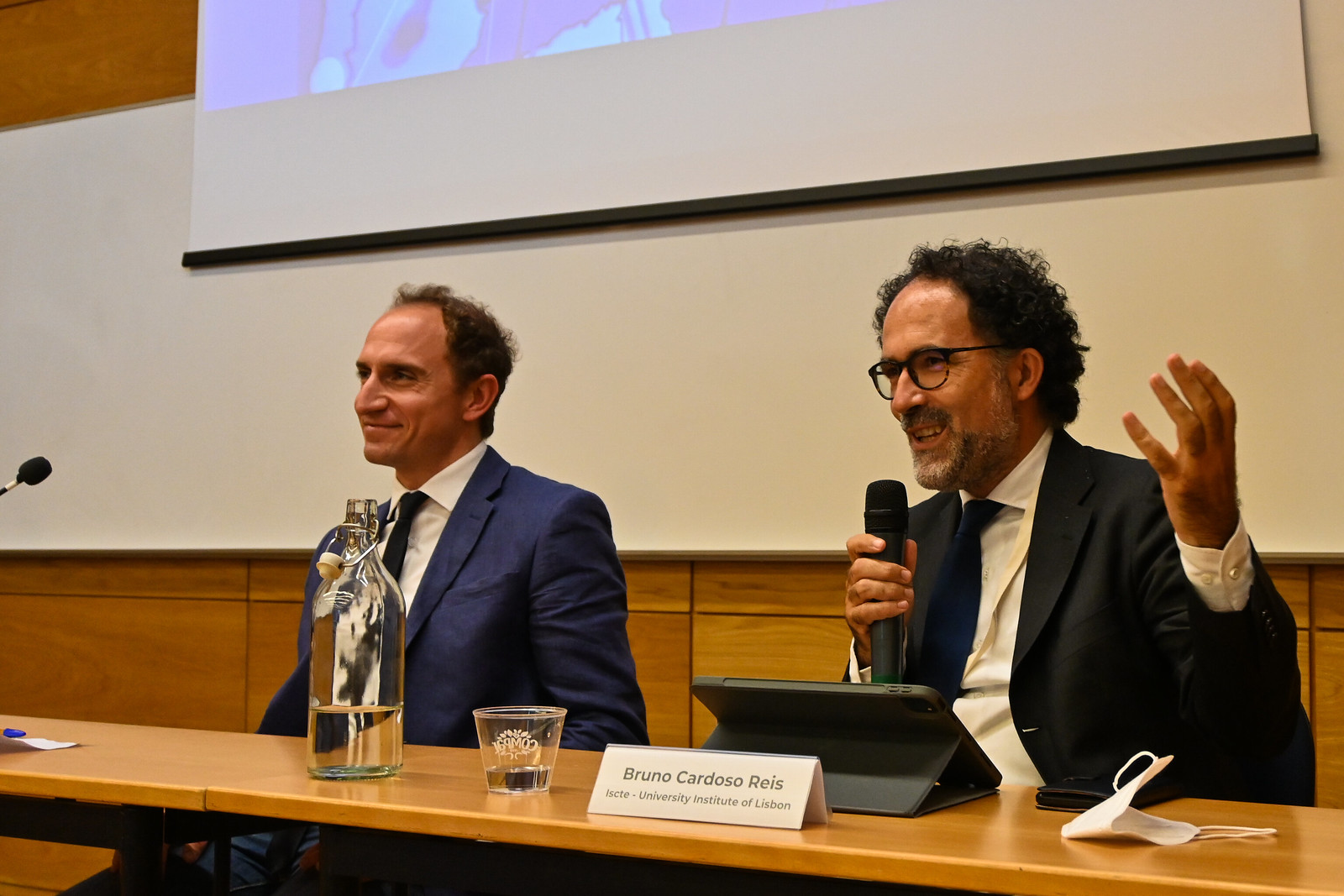 Two panellists at the table, one speaking into a microphone, at the 2021 EISS Conference, Lisbon.